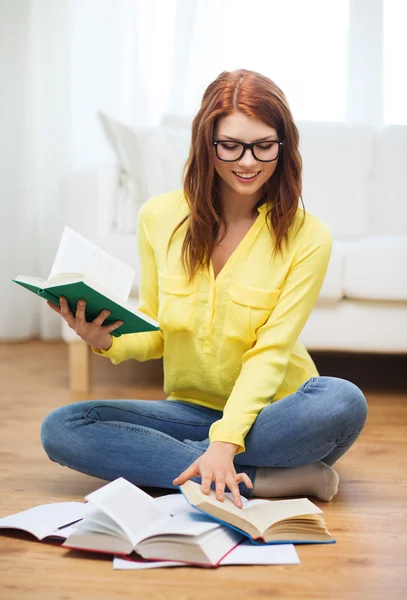 Smiling student girl reading books at home — Stock Photo, Image