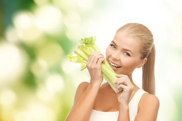 Жінка кусає шматочок селери або зеленого салату — стокове фото