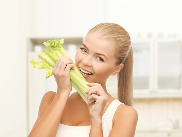 Woman biting piece of celery or green salad — Stock Photo, Image