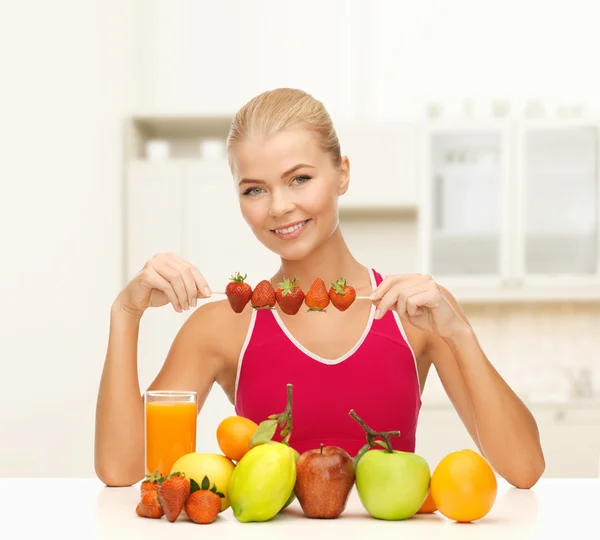 Улыбающаяся молодая женщина с органическими продуктами на столе — стоковое фото