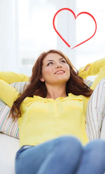 Lächelnde junge Frau liegt zu Hause auf Sofa — Stockfoto