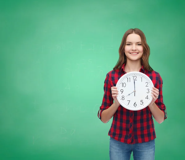 Mujer joven en ropa casual con reloj de pared —  Fotos de Stock