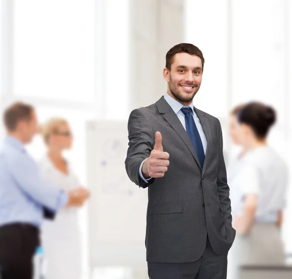 Handsome buisnessman showing thumbs up in office — Stock Photo, Image