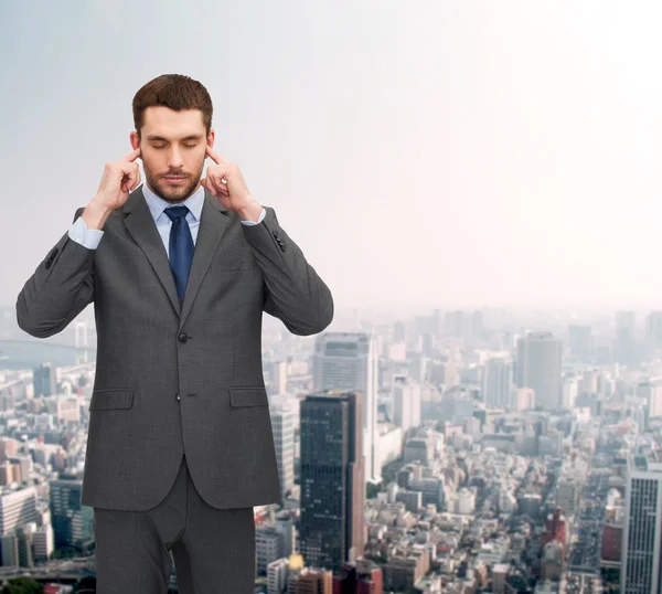 Annoyed businessman covering ears with his hands — Stock Photo, Image