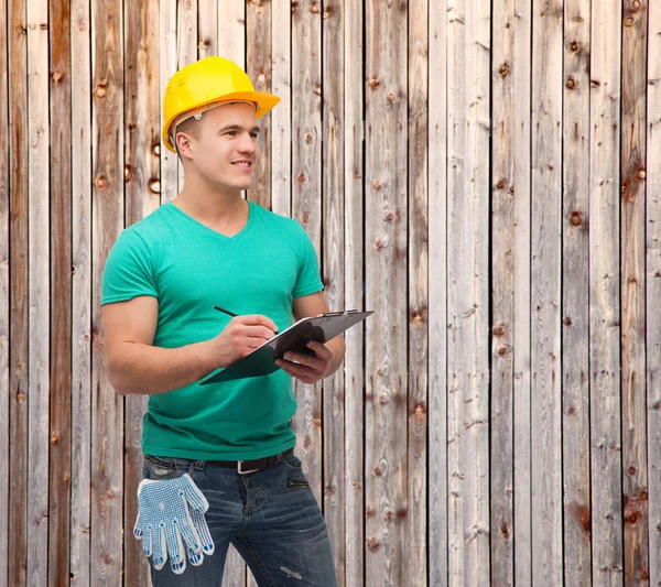 Uomo sorridente in casco con appunti — Foto Stock