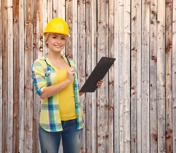 Smiling woman in helmet with clipboard — Stock Photo, Image
