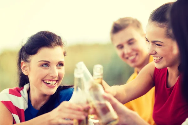 Women and men with drinks on the beach — Stock Photo, Image