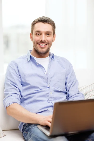 Uśmiechnięty mężczyzna pracujący z laptopa w domu — Zdjęcie stockowe