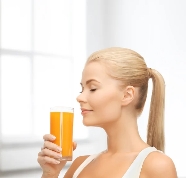 Jovem mulher bebendo suco de laranja — Fotografia de Stock