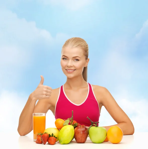 Lachende vrouw met biologisch voedsel of vruchten op tafel — Stockfoto
