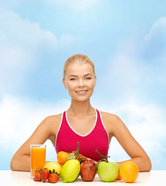 Χαμογελαστή γυναίκα με βιολογικά τρόφιμα ή φρούτα στο τραπέζι — Φωτογραφία Αρχείου