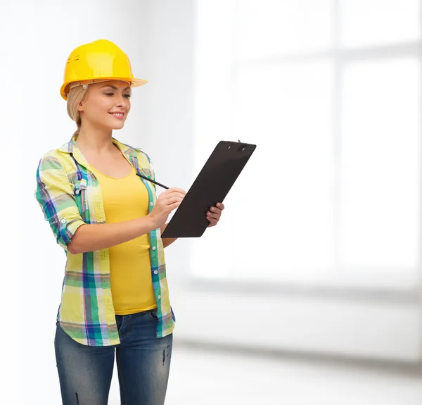 Smiling woman in helmet with clipboard — Stock Photo, Image