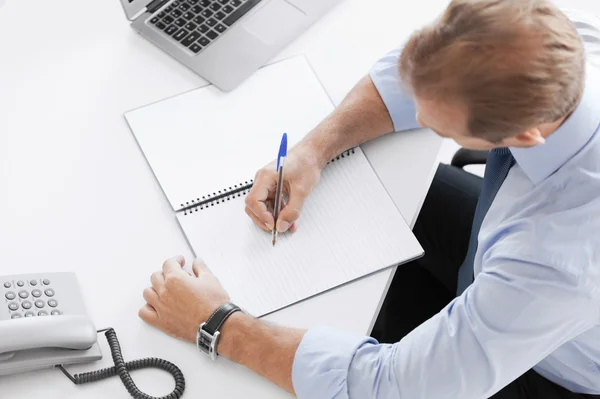 Geschäftsmann schreibt in Notizbuch — Stockfoto