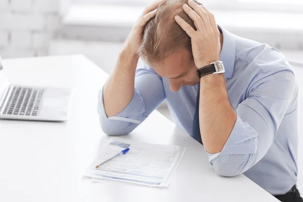 Stressad affärsman med papper på jobbet — Stockfoto