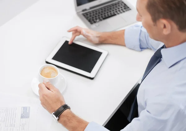 Бизнесмен с планшетным ПК и кофе в офисе — стоковое фото