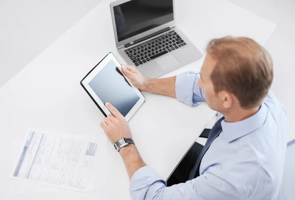 Zakenman met tablet pc en documenten in office — Stockfoto