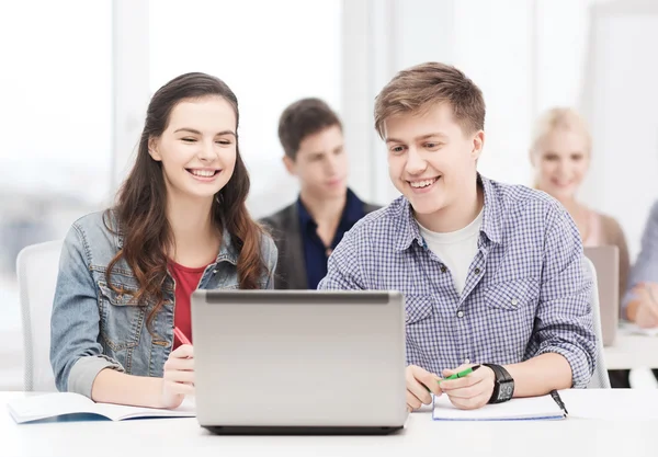 Étudiants avec ordinateur portable et cahiers à l'école — Photo