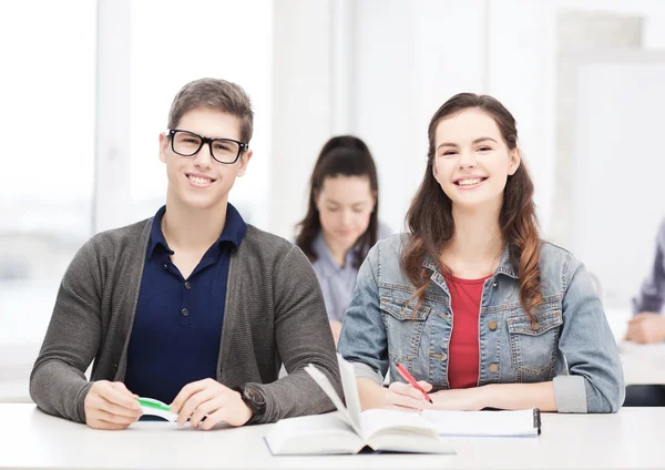 Dos adolescentes con cuadernos y libro en la escuela — Foto de Stock