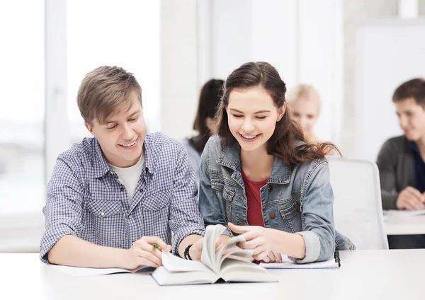 Zwei Teenager mit Notizbüchern und Buch in der Schule — Stockfoto