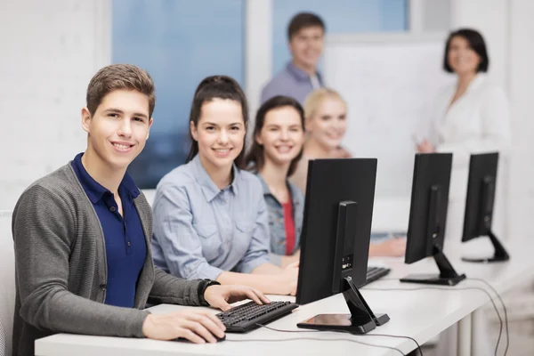 Students with computer monitor at school — Stock Photo, Image