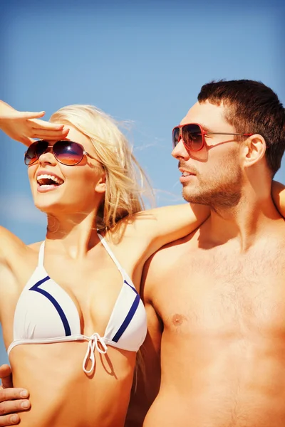 Casal feliz em óculos de sol na praia Imagens De Bancos De Imagens Sem Royalties