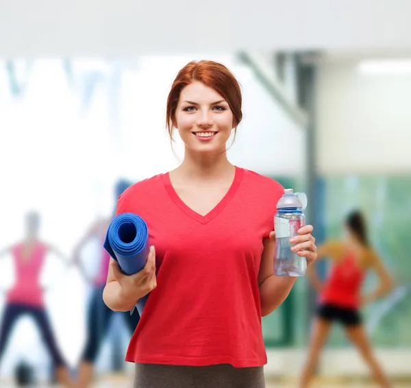 Chica sonriente con botella de agua después de hacer ejercicio —  Fotos de Stock