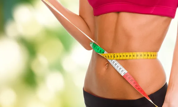 Close up of trained belly with measuring tape — Stock Photo, Image