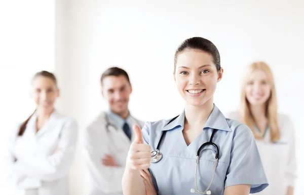 Médico com grupo de médicos mostrando polegares para cima — Fotografia de Stock