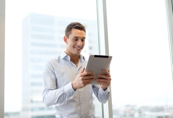 Χαμογελώντας επιχειρηματίας με tablet pc στο γραφείο — Φωτογραφία Αρχείου