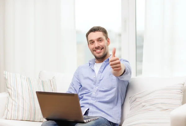 Sonriente hombre trabajando con el ordenador portátil en casa — Foto de Stock