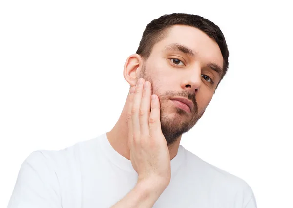 Belo homem calmo tocando seu rosto — Fotografia de Stock