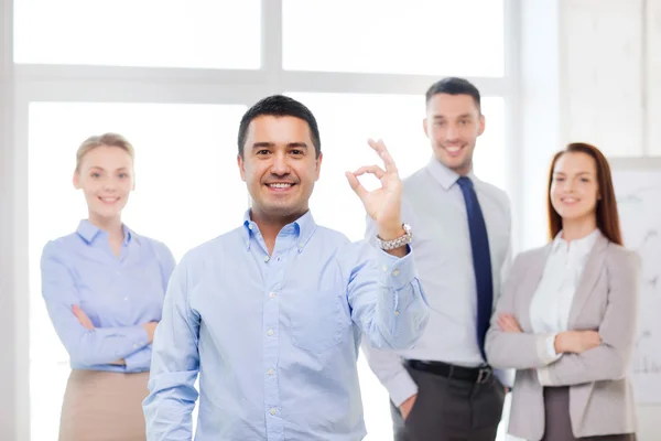 Empresário sorridente mostrando ok-sign no escritório — Fotografia de Stock