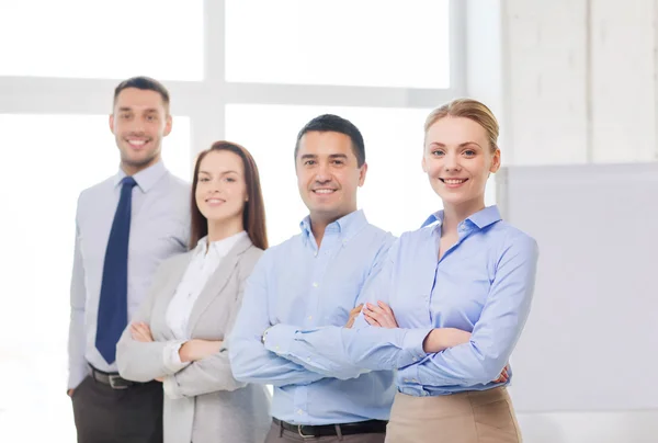 Mujer de negocios sonriente en la oficina con el equipo en la espalda — Foto de Stock