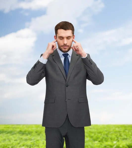 Irriterad affärsman som täcker öronen med händerna — Stockfoto