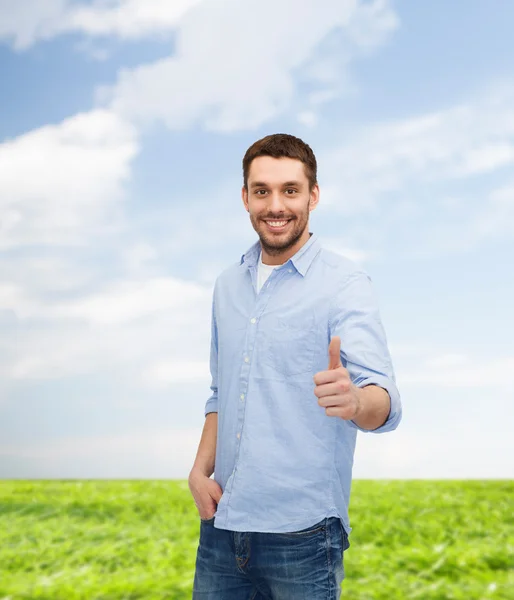 Uomo sorridente mostrando pollici in su — Foto Stock