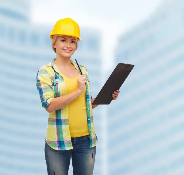 Mujer sonriente en casco con portapapeles —  Fotos de Stock