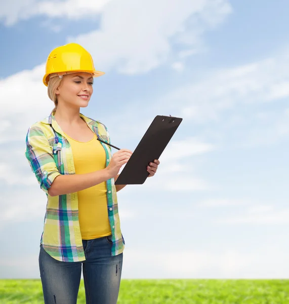 Smiling woman in helmet with clipboard — Stock Photo, Image