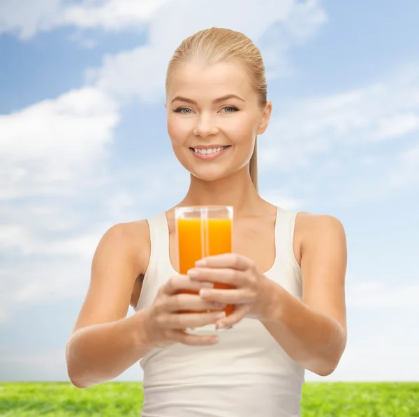 Mujer sonriente sosteniendo un vaso de jugo de naranja — Foto de Stock