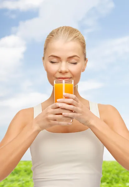 Jovem mulher bebendo suco de laranja — Fotografia de Stock