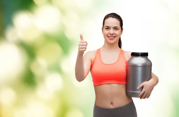 Adolescente con tarro de proteína mostrando los pulgares hacia arriba — Foto de Stock