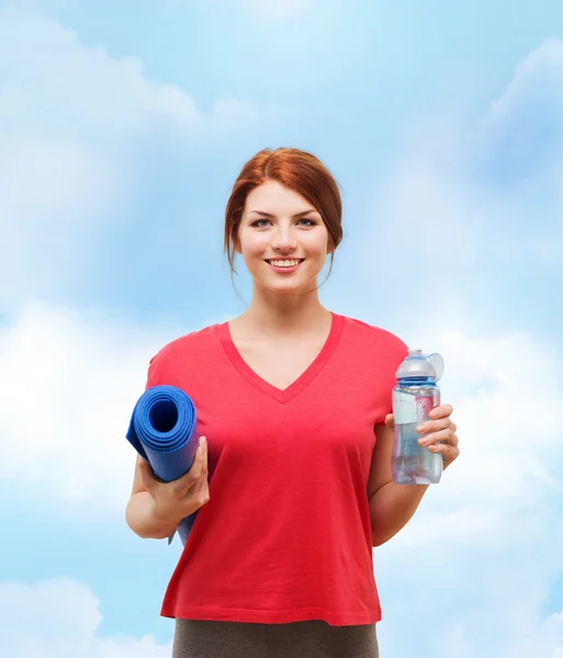 Chica sonriente con botella de agua después de hacer ejercicio — Foto de Stock