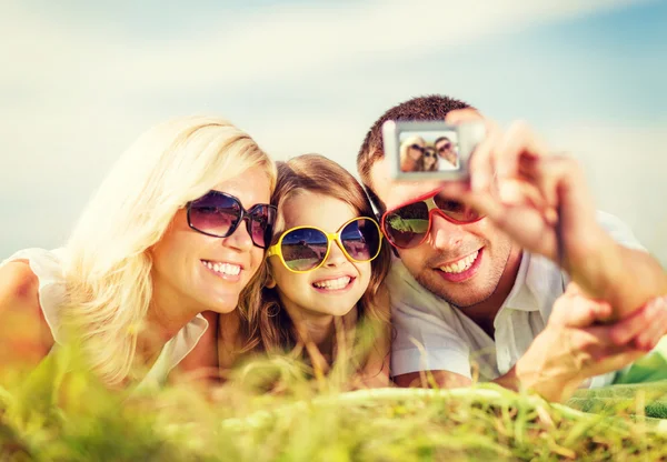 Família feliz com câmera tirando foto — Fotografia de Stock