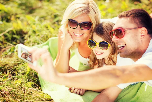 Família feliz com câmera tirando foto — Fotografia de Stock