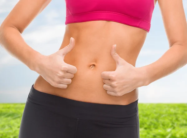 Close up of female abs and hands showing thumbs up — Stock Photo, Image