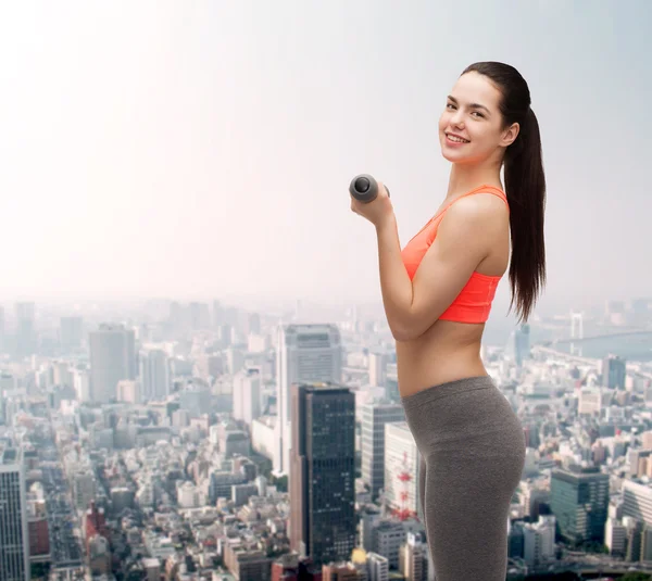 Young sporty woman with light dumbbells — Stock Photo, Image