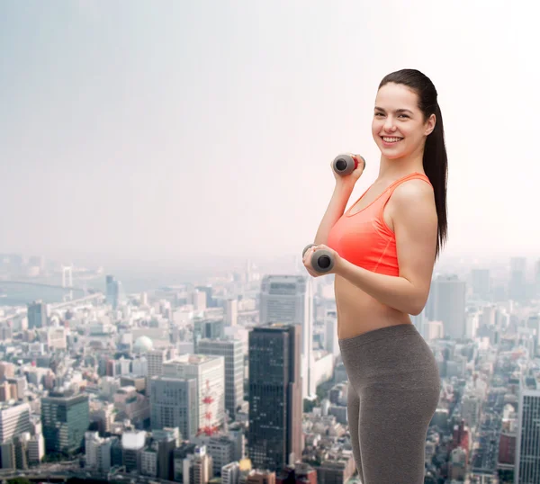 Young sporty woman with light dumbbells — Stock Photo, Image