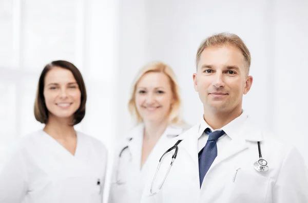 Doctor with stethoscope and colleagues — Stock Photo, Image