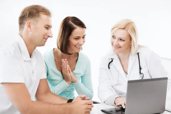 Médecin avec des patients regardant un ordinateur portable — Photo