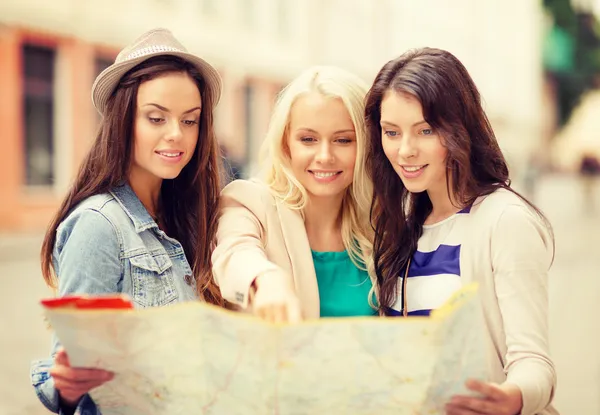 Meninas bonitas olhando para o mapa turístico na cidade — Fotografia de Stock