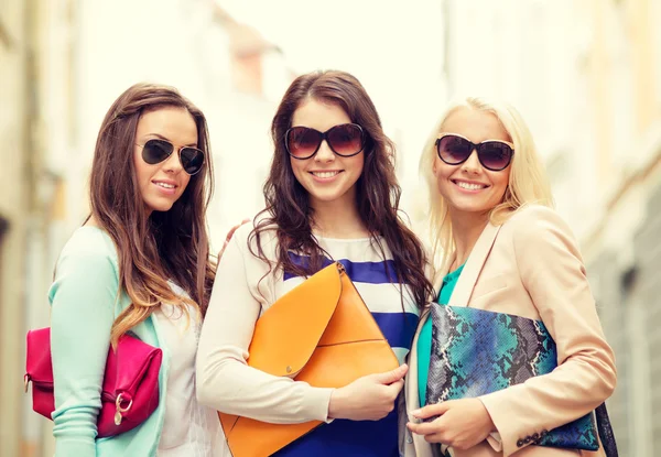 Три улыбающиеся женщины с сумками в городе — стоковое фото